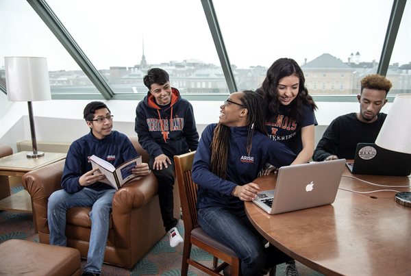 Group of students wearing Illinois gear studying and smiling